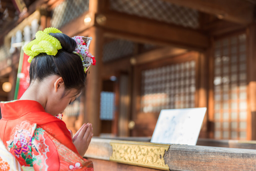 参拝で頭を下げている着物姿の子ども