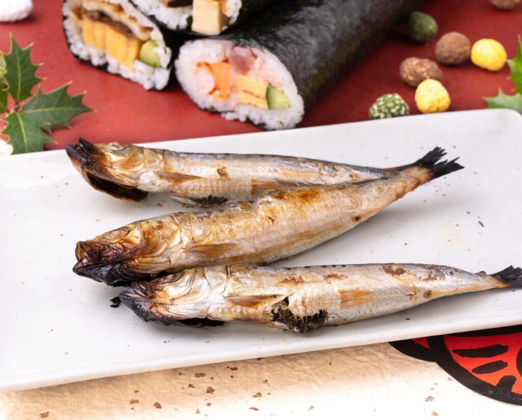 焼かれたイワシと、その奥に置いてある恵方巻